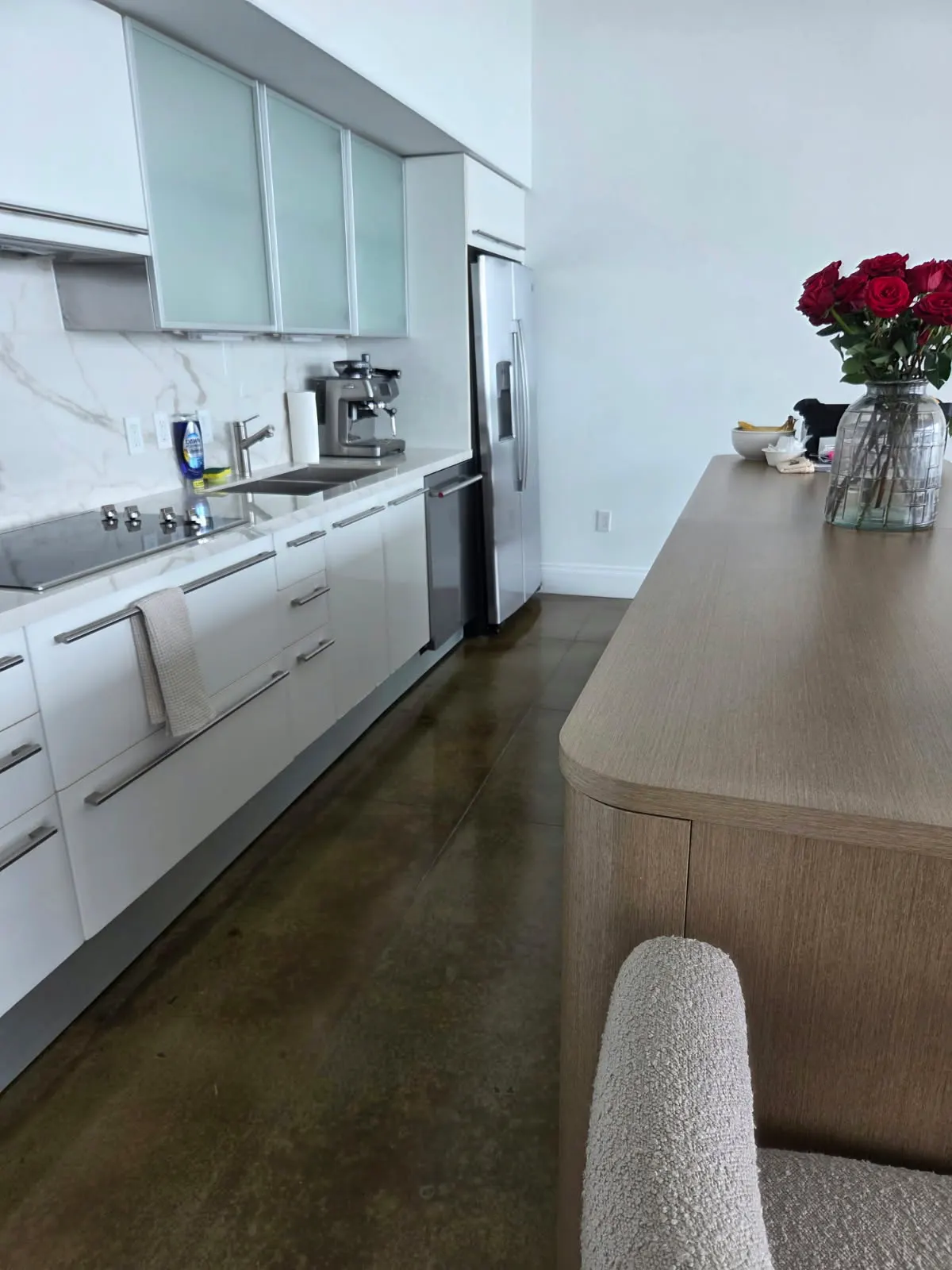Clean kitchen with white cabinets, stainless steel fridge and freshly mopped concrete floor by Alyne Oliver Cleaning in Panama City, FL