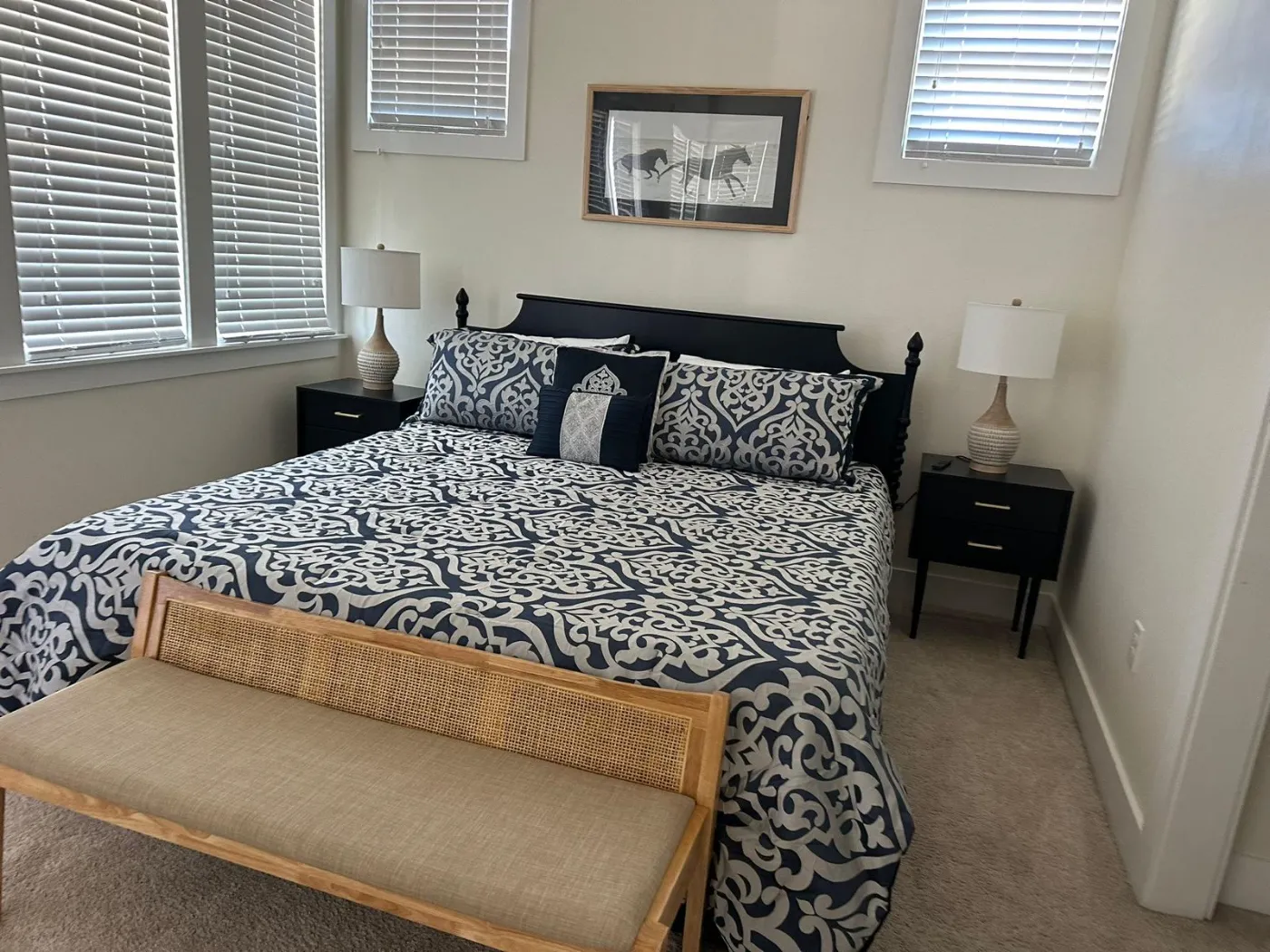 Primary bedroom with a freshly made king bed and dusted nightstands, cleaned by Alyne Oliver Cleaning in Panama City, FL